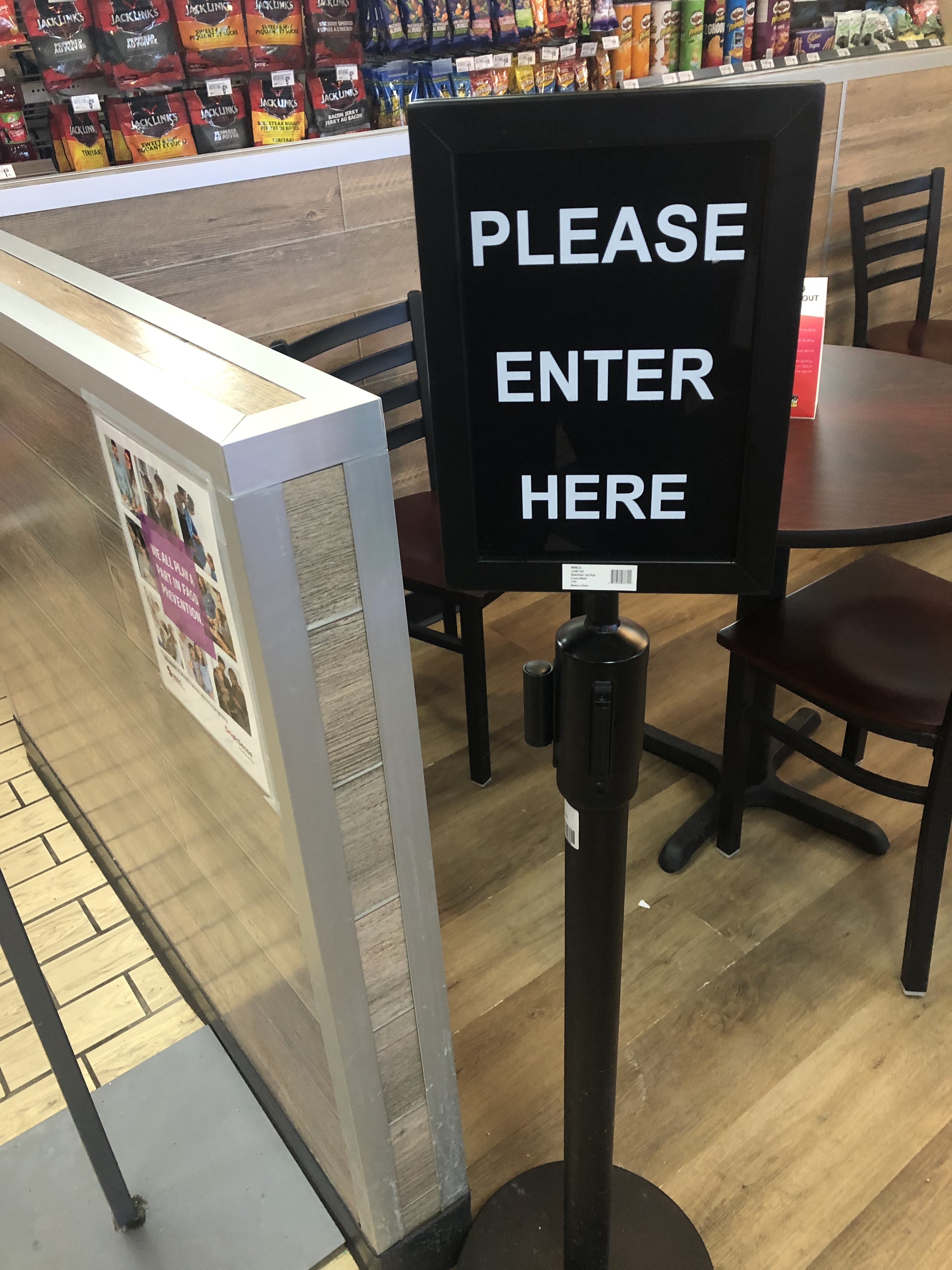 A sign at the entrance to the dining hall that says "Please Enter Here" 