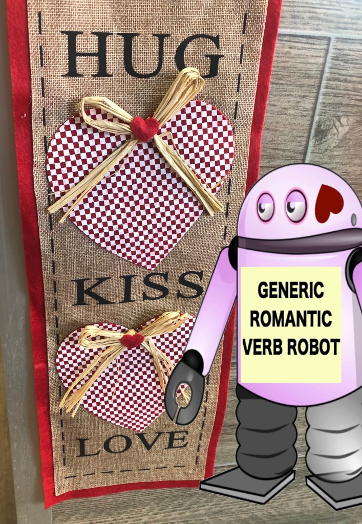 A valentines decoration that says "Hug, Kiss, Love" with a cartoon robot next to named "Generic Romantic Verb Robot." 