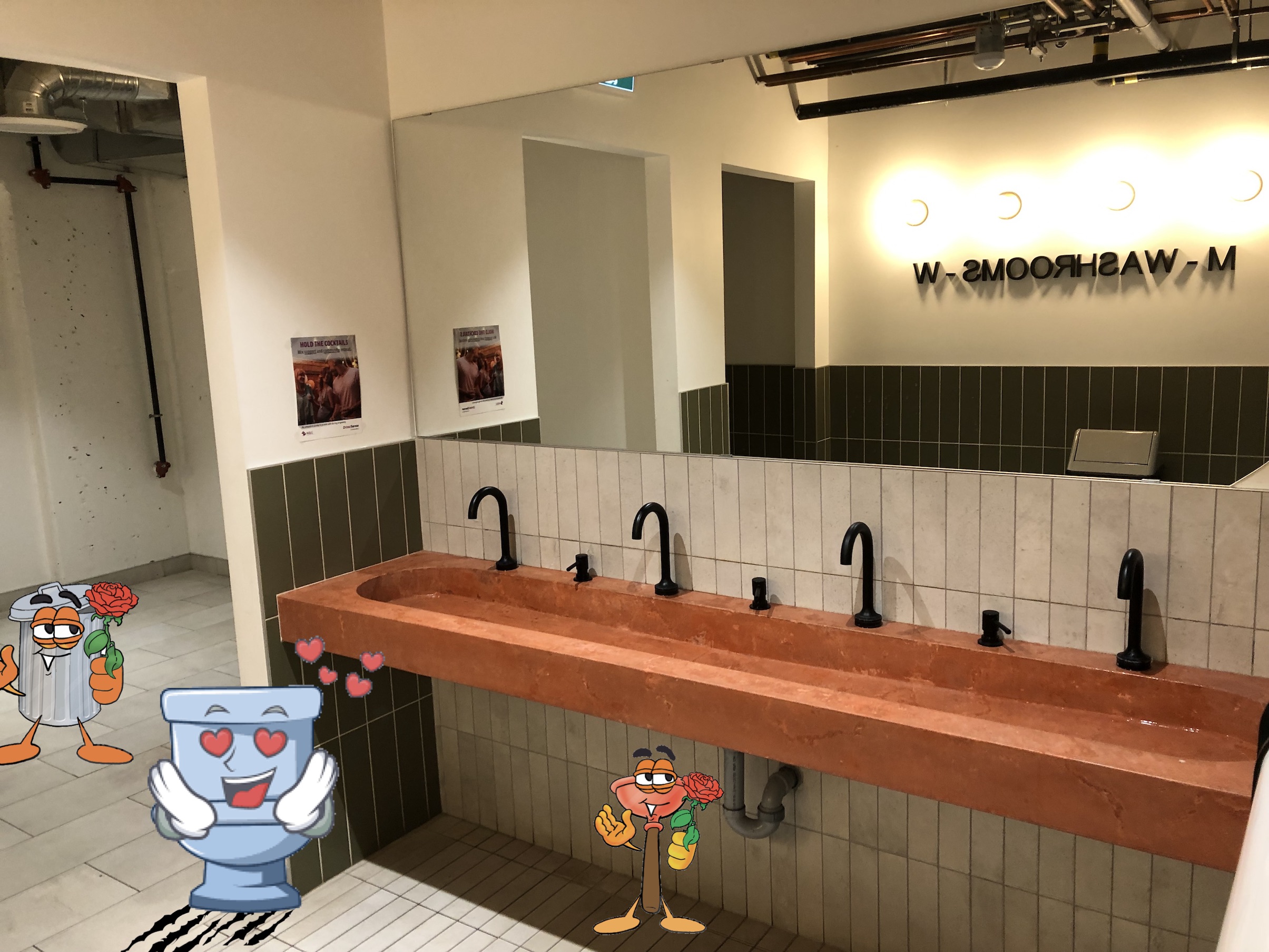 Another shot of the sink, with a plunger, toilet and garbage can all presenting flowers to it, in love.