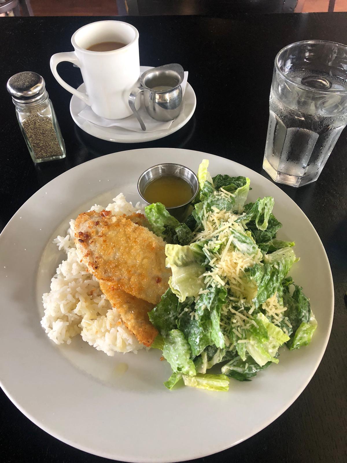 Panko crusted ono, caesar salad, and rice on a plate. 
