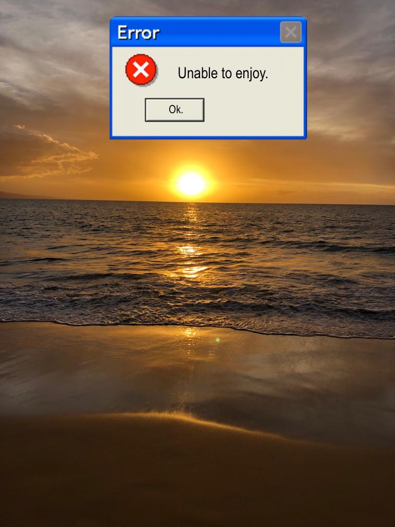 Maui sunset on a beach with an error message pop-up that says "unable to enjoy." 