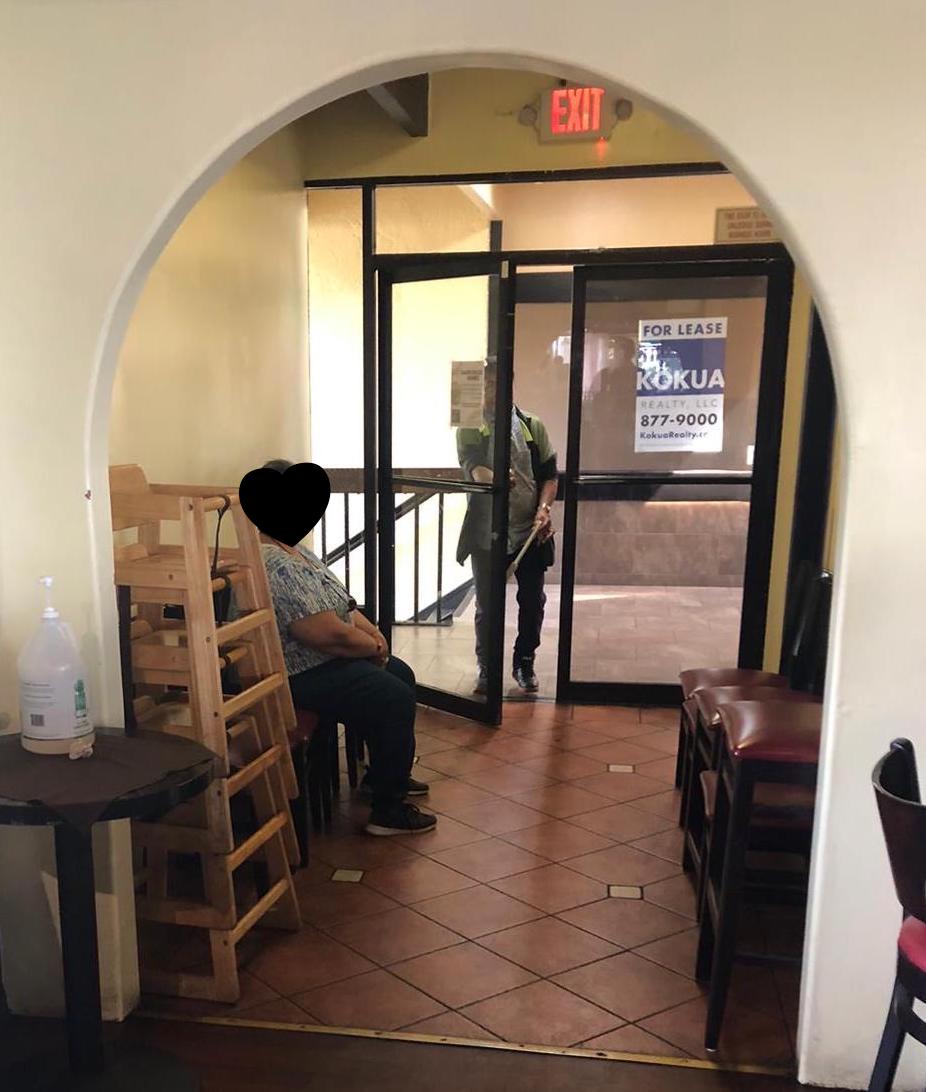 Back entrance to the Café O'Lei leading out to the Restroom. There is a man carrying the washroom key, but you cannot see his face. 